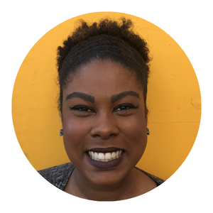 Sydney Woodward, AMFT (she/they) a femme presenting Black person with short natural hair. She is standing in front of a yellow background and smiling brightly into the camera. Sydney offers individual and couples therapy. LGBTQ+ affirming therapy.
