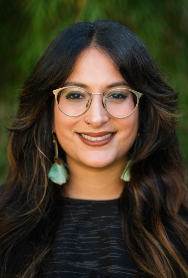 Headshot of Dr. Amelia Jayanty, California online therapist. Amelia is a multiracial South Asian & Sicilian woman with glasses and long dark hair.