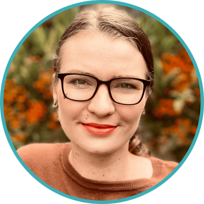 Photo of San Francisco therapist Megan Sullivan-Tuba. Megan is a white woman with brown hair pulled back. She is wearing glasses and red lipstick.