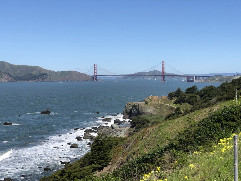 A photo of the Golden Gate Bridge on a sunny day, taken from Lands End. Hiking by the Bay is a great self-care idea!