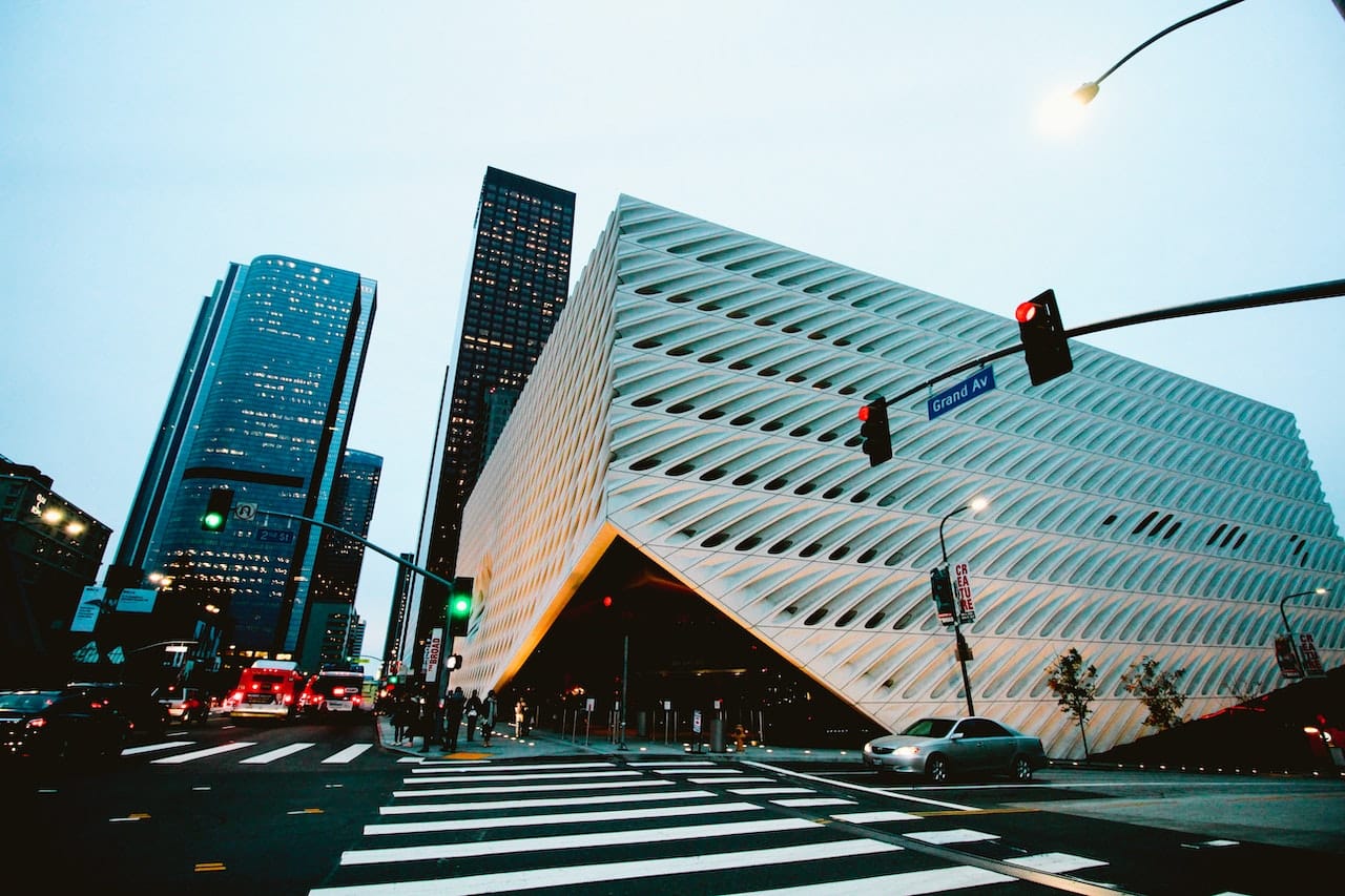 Photo of the Broad Museum, a modern, white building on an LA street corner photographed at dusk.
