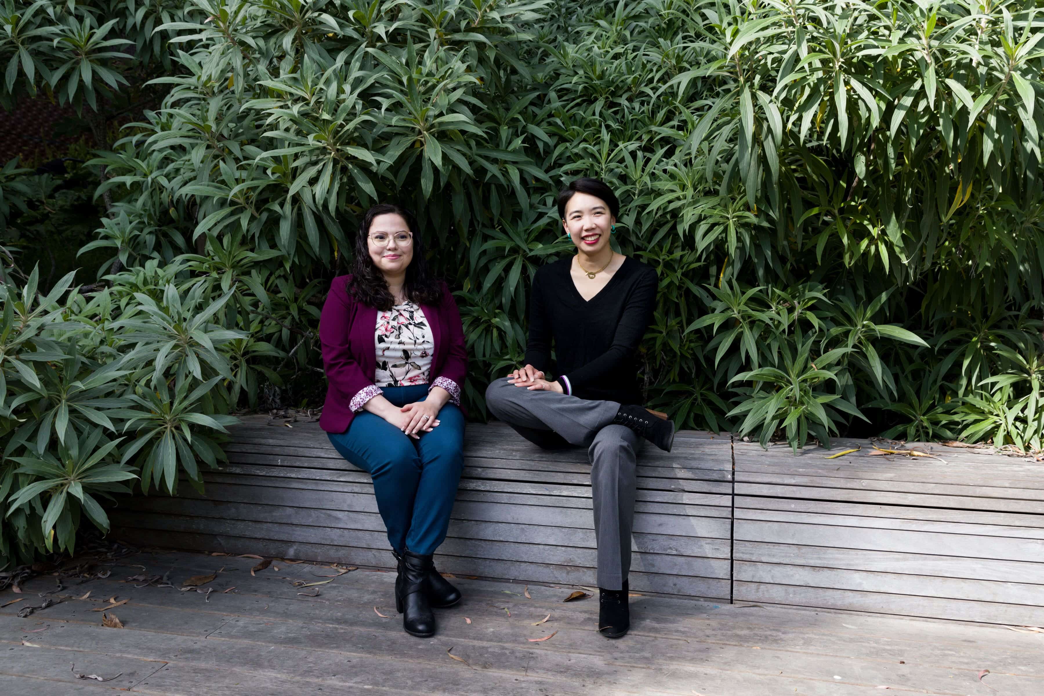 Trauma psychologist Dr. Alexis Lopez and San Francisco therapist Dr. Justine Fan relax on a park bench in Golden Gate Park.