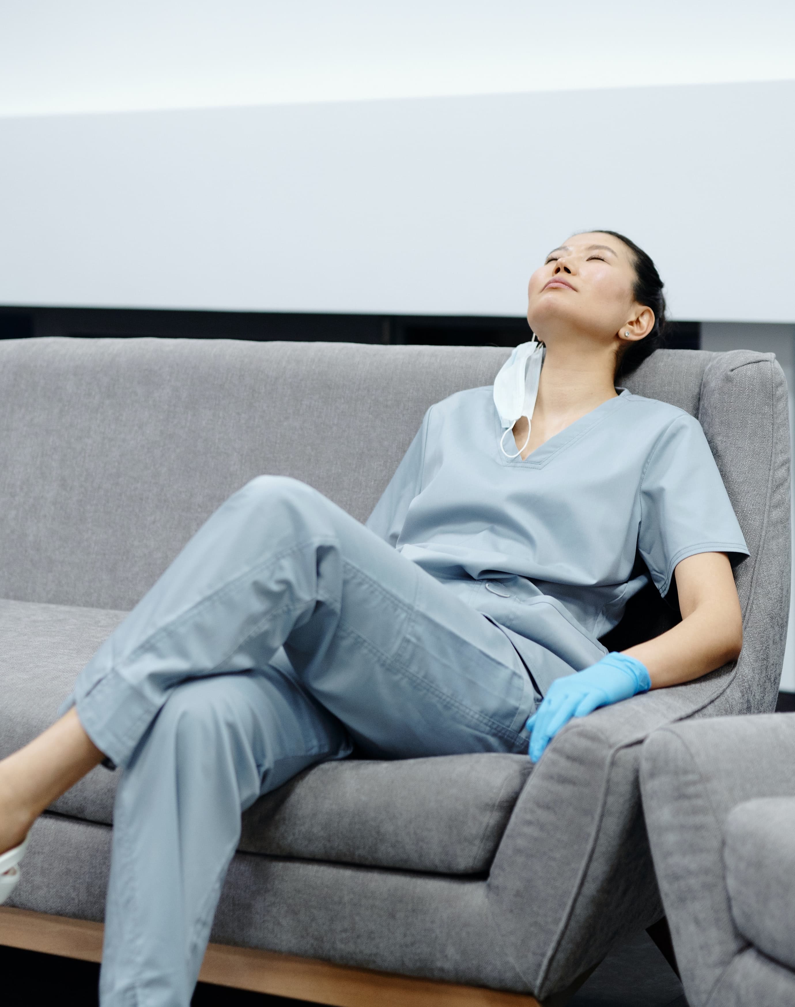 Stock photo of Asian American doctor relaxing on the sofa after work. 